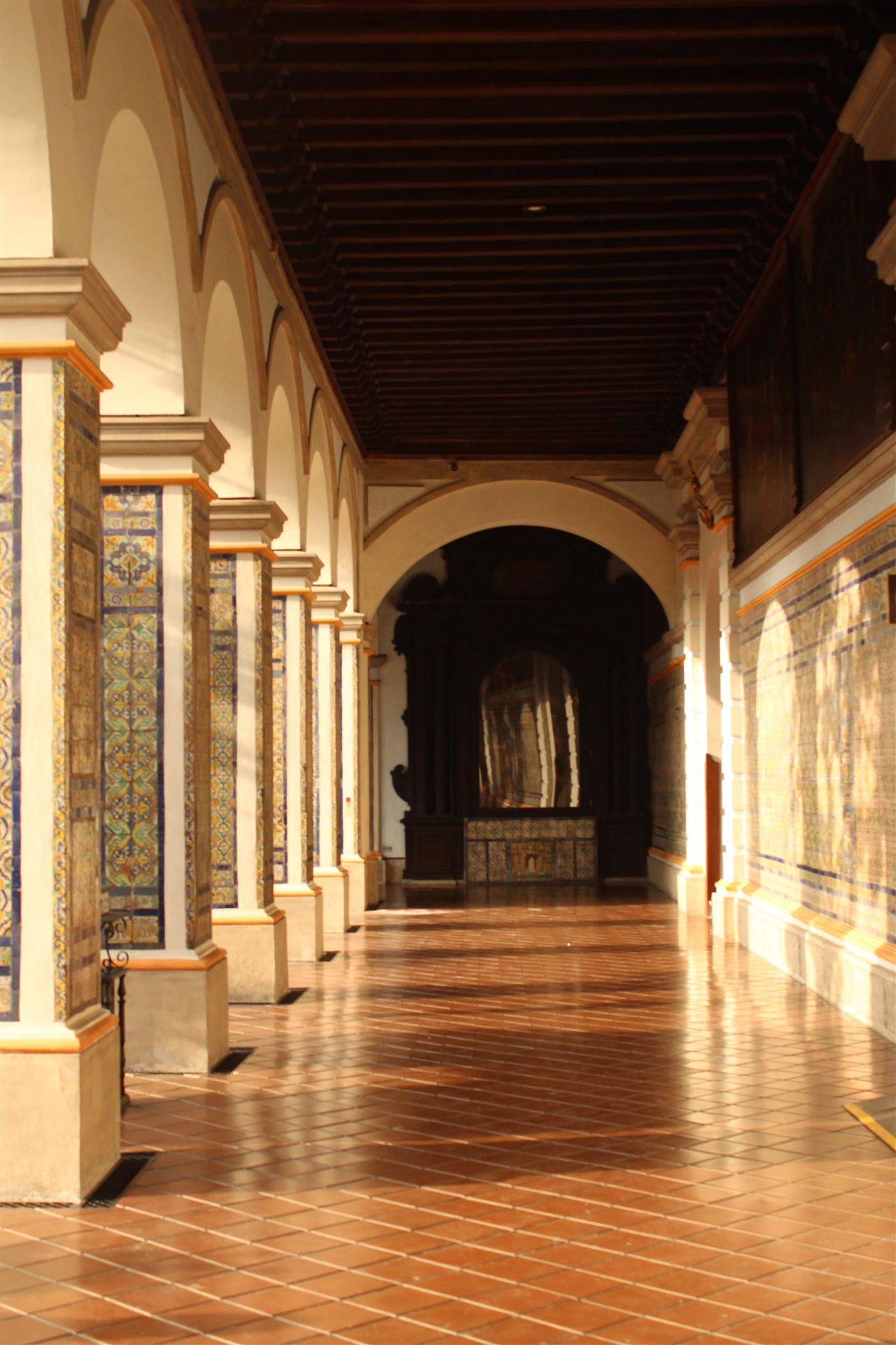 Sunlit tiled cloister corridor
