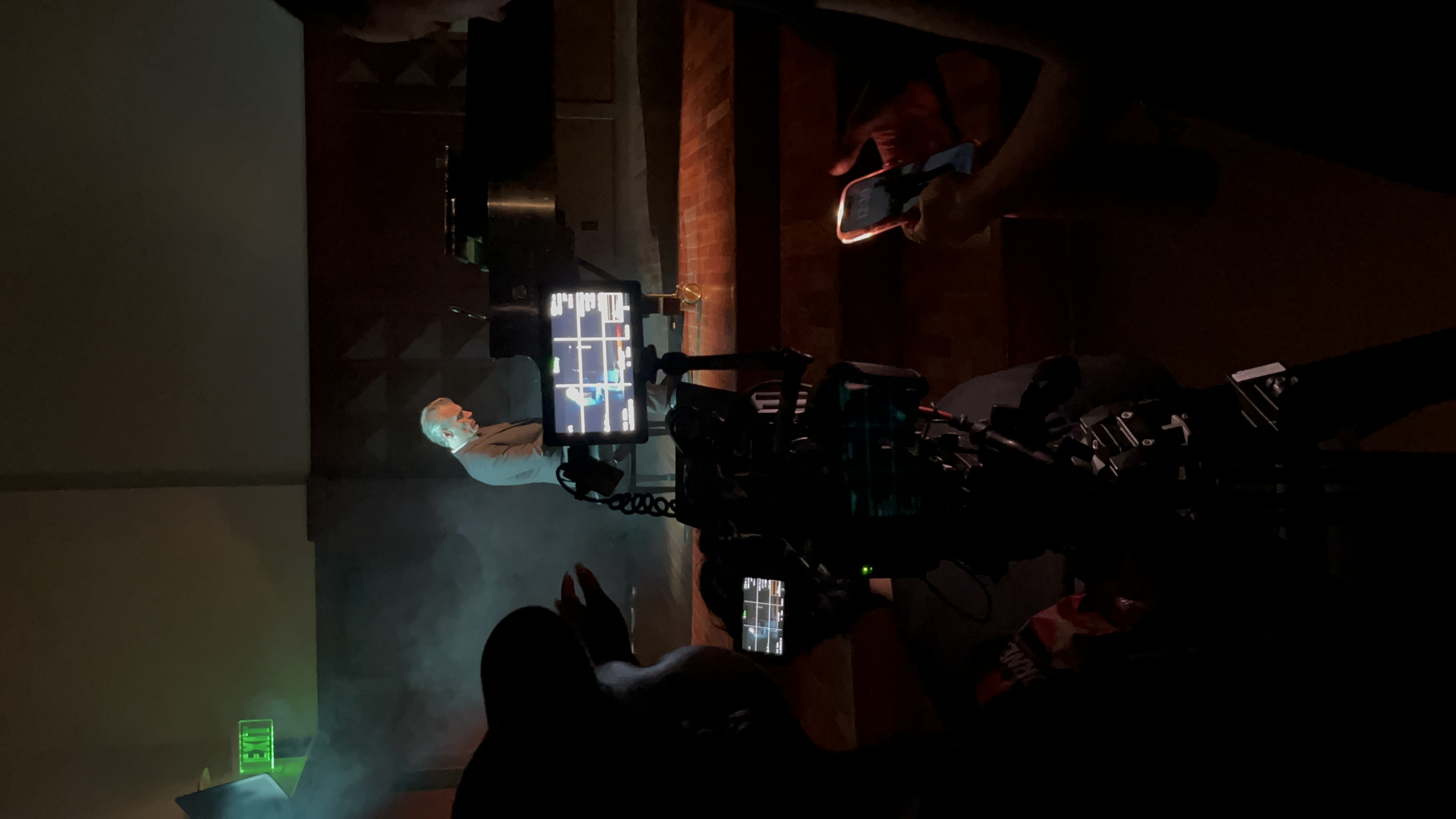 Behind the scenes filming a pianist on a dramatic set